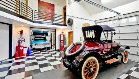 Custom Lochwood-Lozier man cave with checkerboard tile and balcony showcases vintage cars