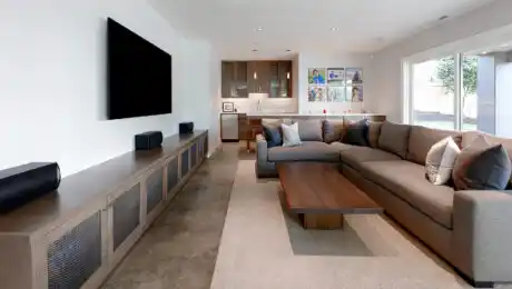 Custom urban modern media room with L-shaped couch and built-in media cabinets