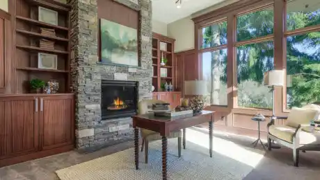 Lochwood-Lozier custom den fireplace with stone cladding, alcove cupboards, and writing desk